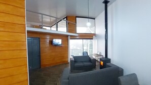 Een moderne woonkamer met een bank, een televisie en een open haard.