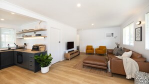 A modern apartment with a kitchen, dining area, and living room. - Barney's Beach House - A Haven of Comfort and Style (Narrawallee)