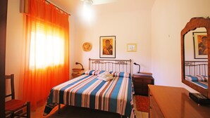 A bedroom with a bed, a desk, a chair, a ceiling fan, and a mirror. - Gorgeous Beach House (Alcamo)
