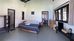 Un dormitorio con cama, mesita de noche y televisor.