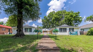 A pathway leading to a row of single-story houses with a sign for corporate rentals. - Serenity Haven with ShellCrestCorp Apt 106 (Memphis)