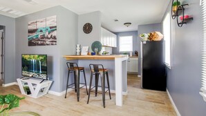 A modern kitchen with a bar area, white cabinets, and a black refrigerator. - Serenity Haven with ShellCrestCorp Apt 106 (Memphis)