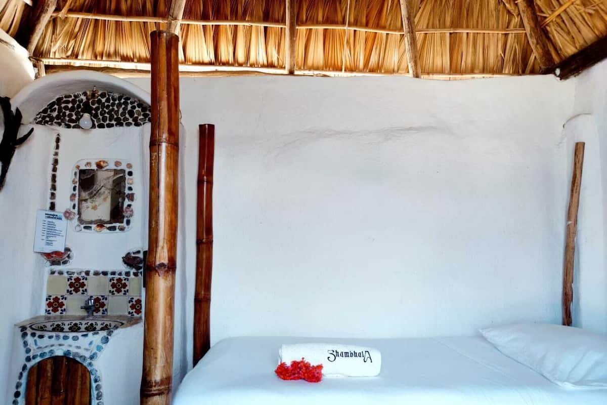 A room with a bed, a small table, and a decorative wall.