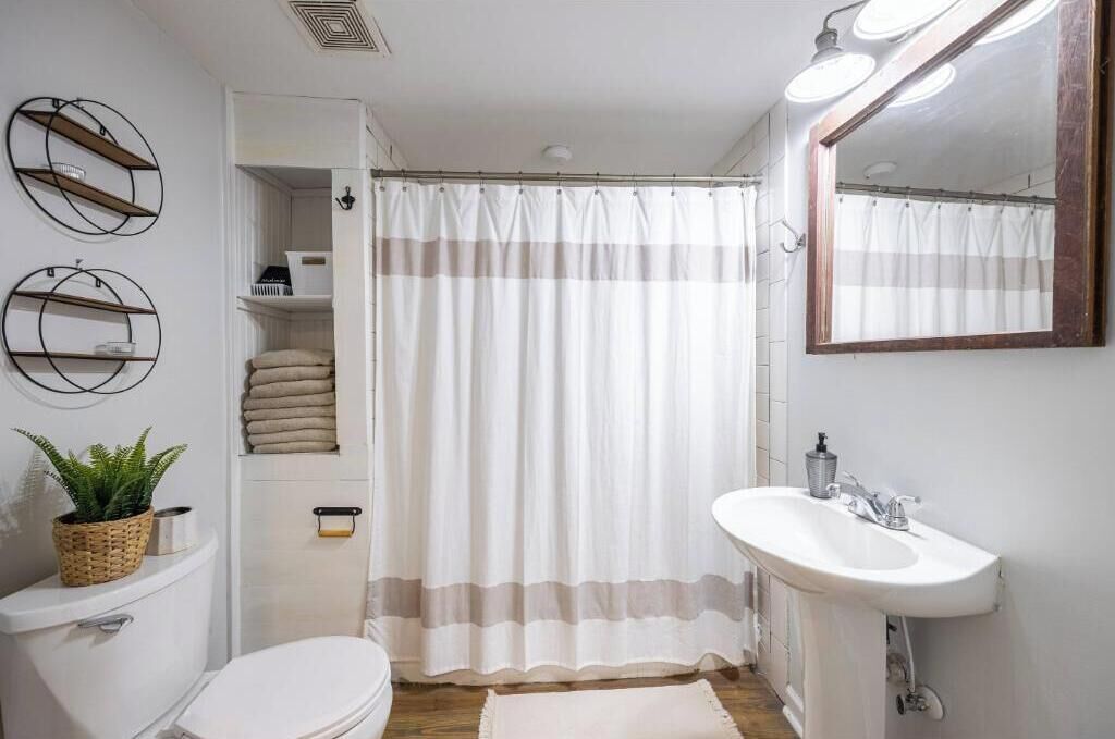 Een badkamer met toilet, wastafel en douchegordijn.
