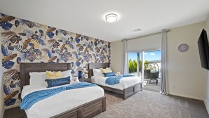 Un dormitorio con dos camas, un ventanal y vistas al verdor exterior.