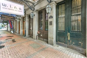 A building facade with a sign for 'wine institute new orleans' and a door labeled '610'.