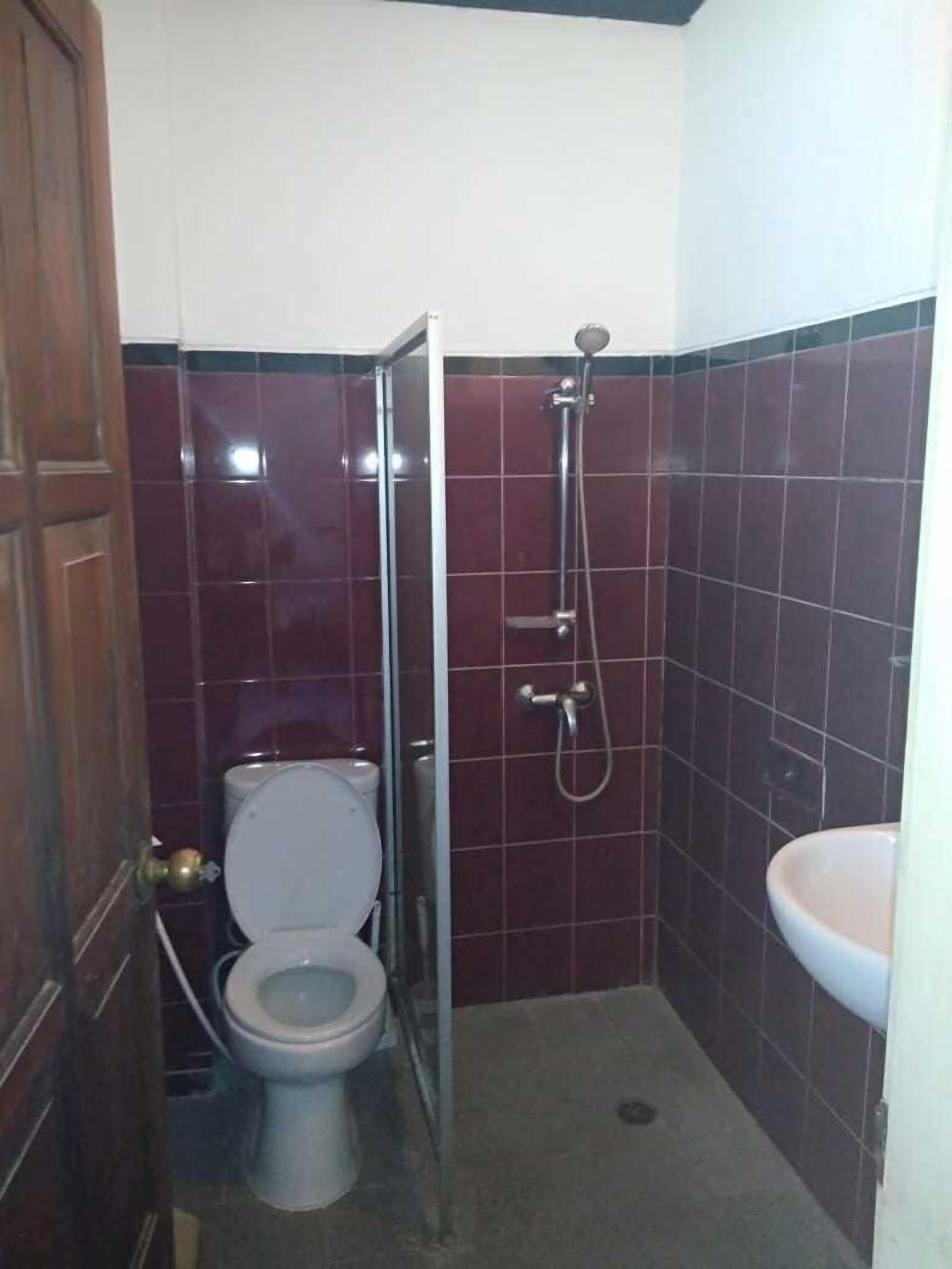 A small bathroom with a toilet, a shower, and a sink.