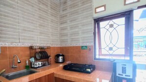 Une cuisine de taille réduite, équipée d’un évier, d’une cuisinière et d’un petit réfrigérateur.