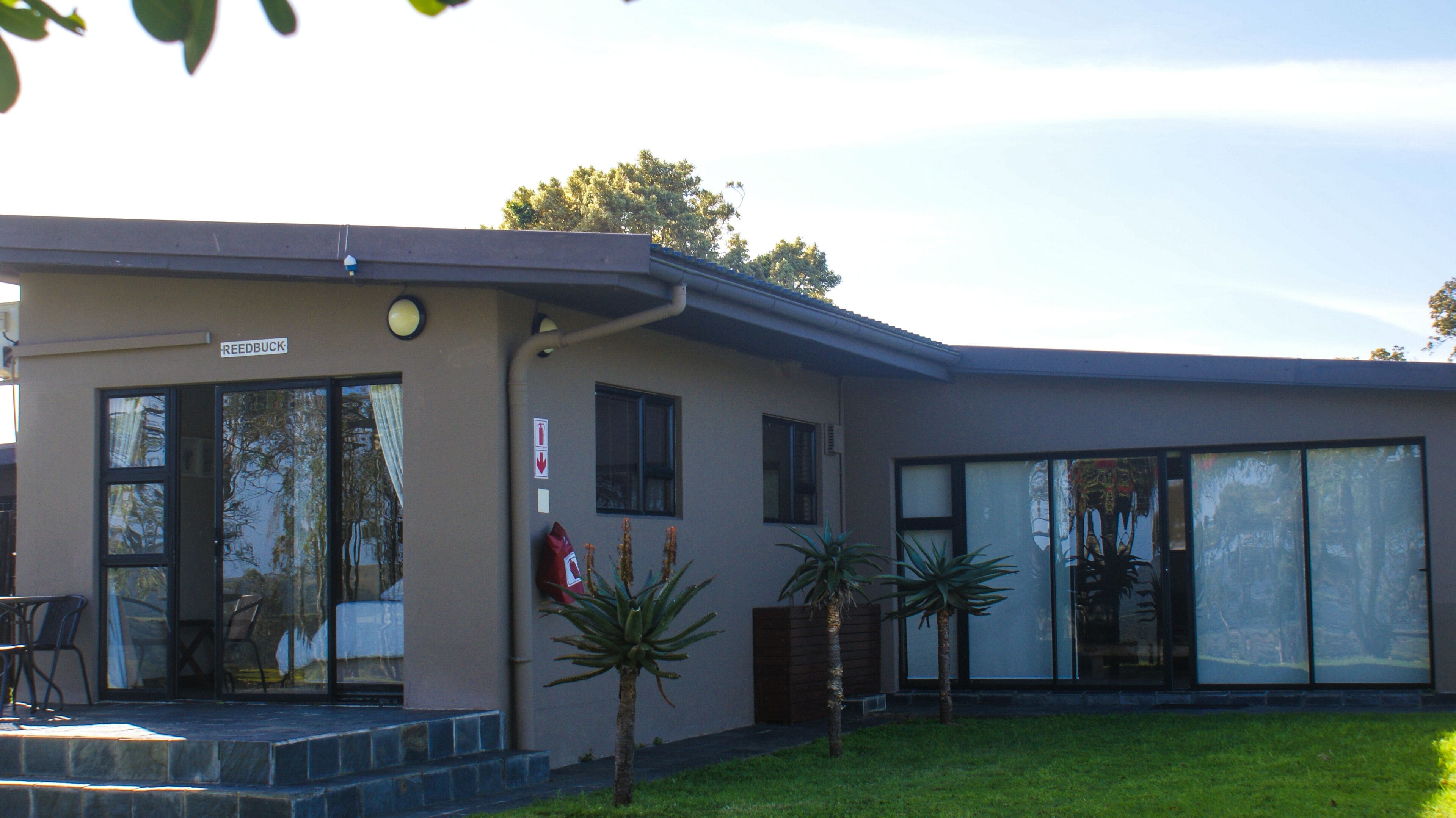 A building with a sign reading "REEDBUCK" and a glass door entrance.