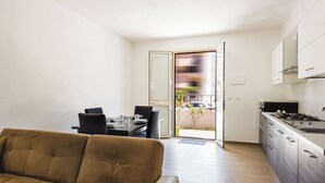 A modern apartment with a living room, dining area, and kitchen. - Casa Lilium a Floridia by Wonderful Italy (Floridia)