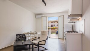 A modern apartment with a dining area, a kitchen, and a view of the outside. - Casa Lilium a Floridia by Wonderful Italy (Floridia)