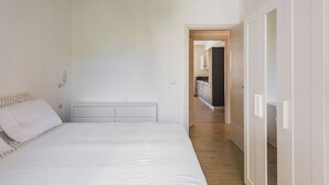 A bedroom with a bed, a bedside lamp, and a wooden floor. - Casa Lilium a Floridia by Wonderful Italy (Floridia)