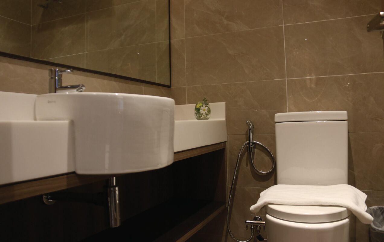 A bathroom with a sink, mirror, toilet, and shower.