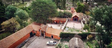 A rural village with terracotta-roofed buildings, a church, and a white pickup truck parked in front.