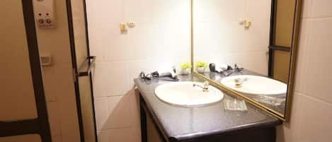 Un baño con dos lavamanos, un espejo y un perchero para toallas.