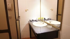 A bathroom with two sinks, a mirror, and a towel rack. - Museo Hacienda Cayara (POTOSI)