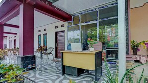 Una zona de recepción con escritorio, sillas y plantas en macetas.