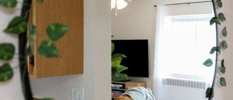Una habitación con una cama, un televisor y una ventana.