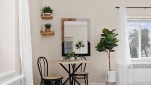 A room with a round table, two chairs, a mirror, and potted plants. - Sleeps 7{SPACIOUS}Pets Welcome! (Sheboygan)