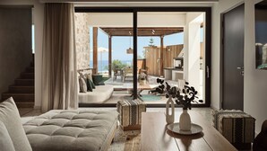 A modern living room with a sofa, a wooden coffee table, and a view of an outdoor patio with a pool and dining area.