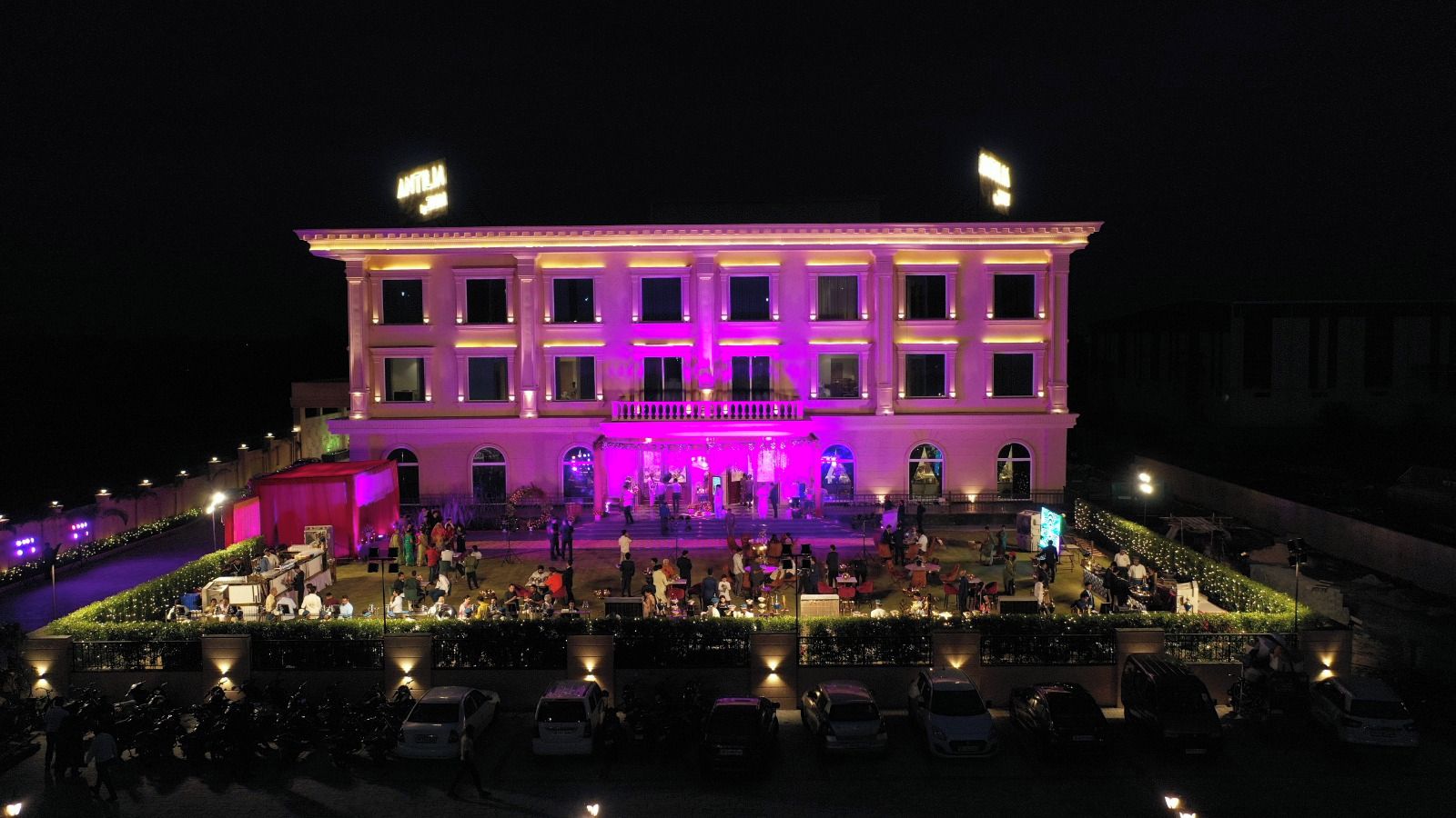 A large, multi-story building with a central stage and seating area, surrounded by a landscaped garden.