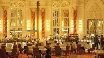 A grand hotel lobby with ornate chandeliers, large windows, and plush seating areas.