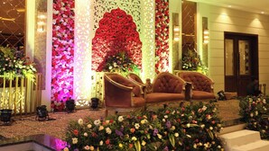 Un vestíbulo con una pared floral, zona de estar y una escalera.
