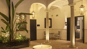 Una hall con una fontana centrale, colonne e un'area salotto.