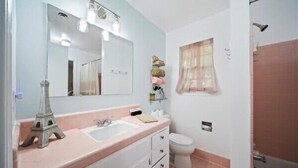 A bathroom with a sink, mirror, vanity, toilet, and shower. - Spacious 4/2BR Home |Pet-Friendly |Midtown Tulsa (Tulsa)