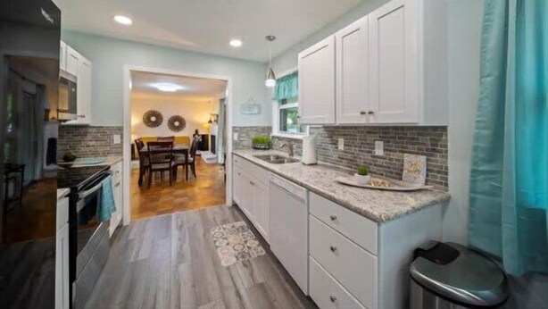 A modern kitchen with white cabinets, a granite countertop, and a dining area with a wooden table and chairs. - Spacious 4/2BR Home |Pet-Friendly |Midtown Tulsa (Tulsa)
