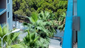 Un immeuble de grande hauteur offrant une vue sur l’océan et une végétation luxuriante en contrebas.