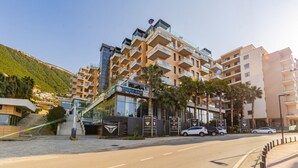 Un hôtel à plusieurs étages doté de balcons, d’un bar-restaurant et d’un espace aménagé sur le toit.