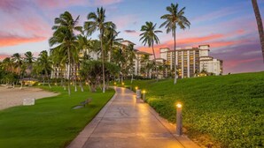 A pathway leading to a hotel with palm trees and a sunset in the background. - Hale Pikake O-406 Comfort and Joy in one place (Kapolei)
