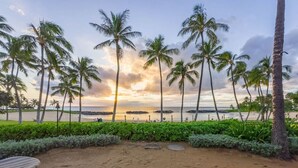 A beachside lounge with lounge chairs and a view of the ocean at sunset. - Hale Pikake O-406 Comfort and Joy in one place (Kapolei)
