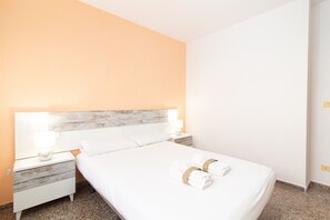 Una camera d'albergo con un letto, due comodini e un tavolino da notte.