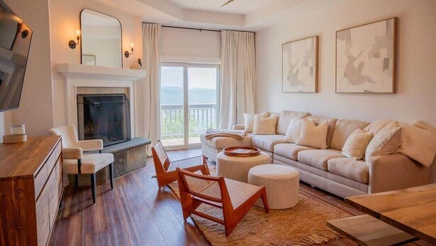 Una sala de estar moderna con chimenea, un juego de sofá, una mesa de centro y un televisor.