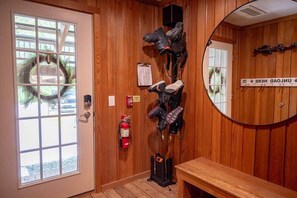 A wooden-paneled room with a large mirror, a fire extinguisher, and a bench. - Mountainside 2-BR Ski-In/Out Okemo Haven (Ludlow)