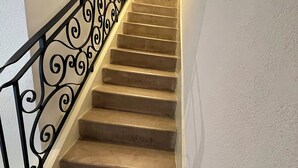 A staircase with a black wrought iron railing and beige steps. - N°9, in the heart of the Haut Doubs tourist region, 10 minutes from Switzerland (Damprichard)