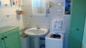 A small bathroom with a sink, mirror, and green cabinet.