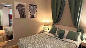 A bedroom with a bed, a nightstand, a lamp, a mirror, and artwork on the wall. - Piso, Apartamento, Centro de Madrid (Madrid)