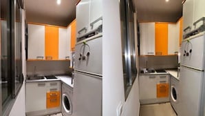 A compact kitchen with a washing machine, a sink, and a stove. The bathroom includes a toilet, a shower, and a sink. - Piso, Apartamento, Centro de Madrid (Madrid)