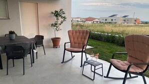 Une terrasse avec une table, des chaises et des plantes en pot.