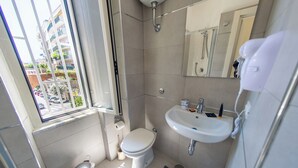 A small bathroom with a toilet, sink, and shower. - A Casa Di Marco (Salerno)