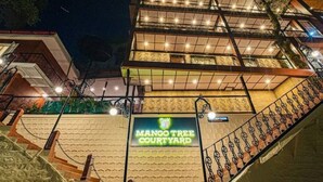 A staircase leading to a building with a sign reading "Mango Tree Courtyard". - Mango Tree Courtyard Mussoorie (Dehradun)