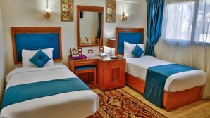 A hotel room with two beds, a wooden desk, a mirror, and a nightstand. - The Palm Hotel Kafr El-Sheikh (Kafr el Shaikh)