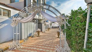 A pathway leading to a building with a decorative archway, potted plants, and a tiled floor. - The Palm Hotel Kafr El-Sheikh (Kafr el Shaikh)