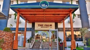 The entrance of The Palm Resort with a covered walkway, a signboard, and a staircase leading to the entrance. - The Palm Hotel Kafr El-Sheikh (Kafr el Shaikh)