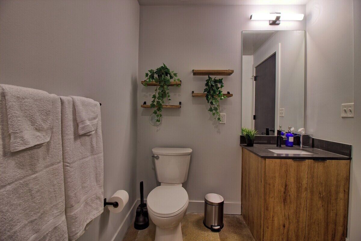 A bathroom with a toilet, a sink, a mirror, and a towel rack.