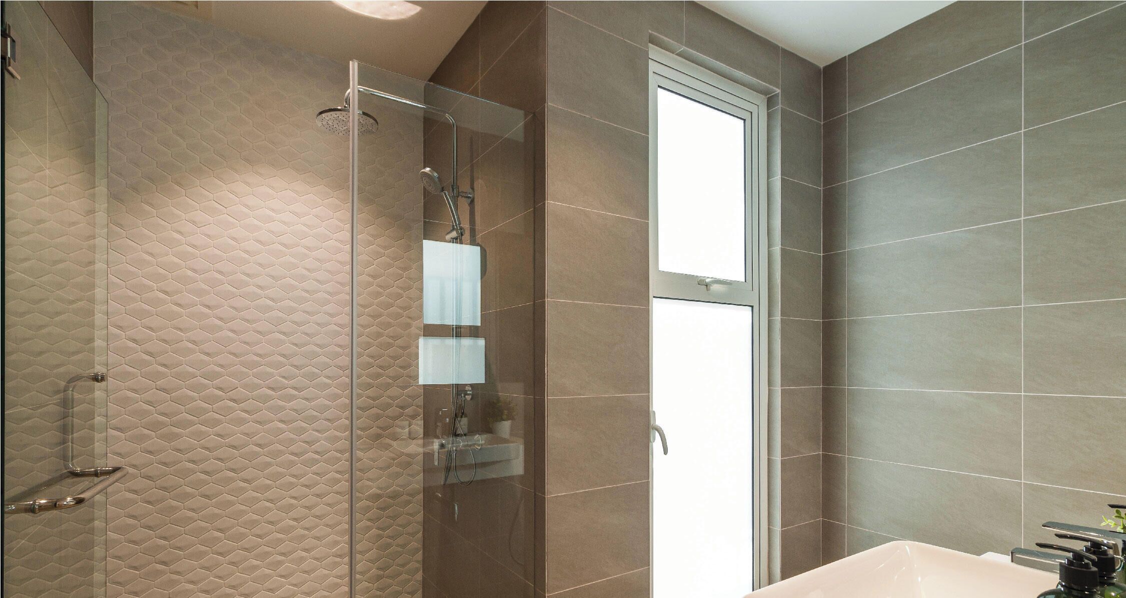 A modern bathroom with a glass shower enclosure, a large mirror, and a bathtub.