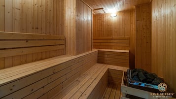 Uma sauna de madeira com bancos e uma bancada com uma bandeja de pedras.